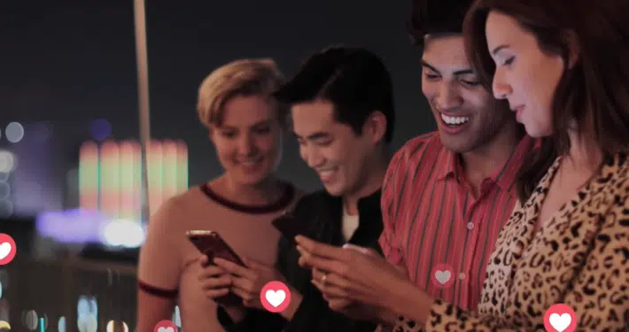 four-people-looking-a-phones-with-hearts